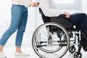 adult helping an individual in a wheelchair