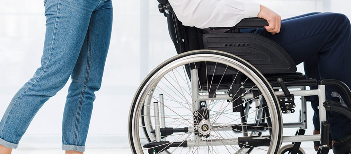 adult helping an individual in a wheelchair